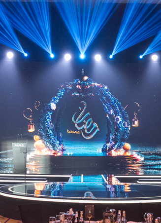 Elegant stage setup for the MBC Group MMS Ceremony, featuring immersive LED arches, dynamic lighting beams, and round dinner tables arranged in a luxurious ballroom environment.
